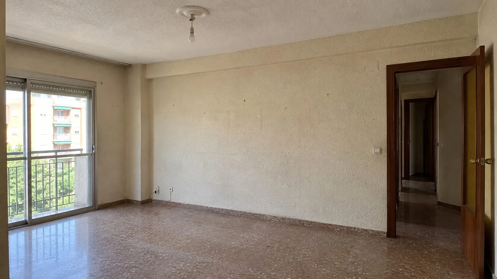 Salón vacío con las paredes desgastadas antes de pintar